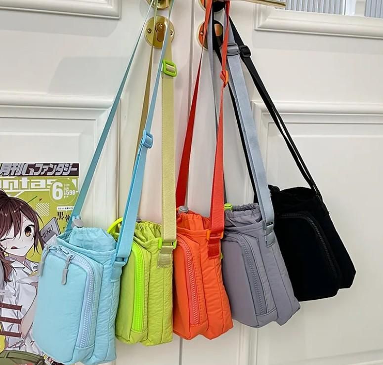 Colorful collection of stylish side sling pouch bags hanging on wall hooks in multiple vibrant colors